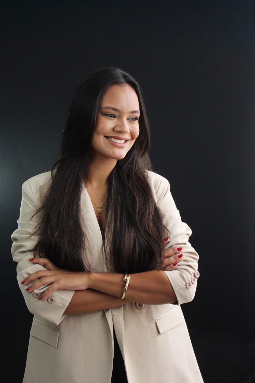 Thassia Moreira sorrindo, em ambiente de escritório